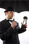 man with bowler hat ,  umbrella  and hour- glass