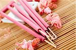 Spa treatment in bright pink and white palette, petals, and arotatizirovannye sticks on a wooden bamboo rug