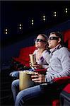 Young couple watching a movie in the cinema