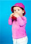 small child with an apple on a blue background