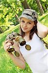 woman in the cap holds the binoculars