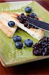 Toasts with blueberry jam and fresh blueberries. Shallow dof