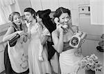 Woman on phone while friends give young woman cigarette and alcohol in a retro styled kitchen scene