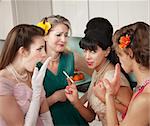 Four Caucasian women gossiping in a kitchen