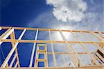 New residential construction home framing against a blue sky