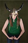 Tough-looking woman in Viking helmet flexes her biceps