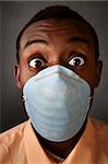 Wide-eyed Black man wearing a surgical mask
