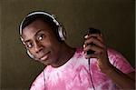 Serious African-American with headphones holds an mp3 player