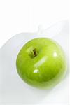 green apple on a apple shaped dish over white