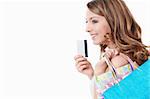 Beautiful girl with a credit card and shopping bags on white background