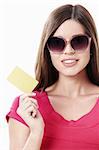 Young girl in sunglasses with a credit card on a white background