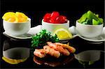 photo of grilled  king prawns on black glass table with reflection