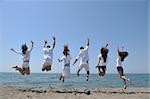 Groupe de gens heureux s'amuser courir et sauter sur la plage magnifique plage de sable