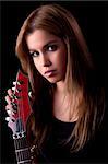 beautiful young woman with a electric guitar, on black, studio shot