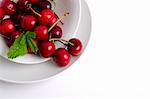 Red fresh cherries on plate background.