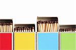 Closeup of few variegated matchboxes in a row on white background. Clipping path is included