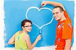 Young couple drawing a heart on the wall during home renovation