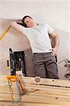 Thoughtful man on the floor with carpentry tools around