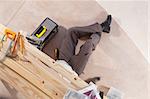 Carpenter working under the table with carpentry tools around