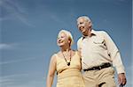 senior caucasian couple walking on sunny day and hugging. Horizontal shape, low angle view, copy space
