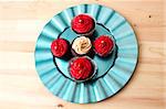 chocolate cupcake with red and coffee icing with pearl on a turquoise plate