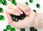 Beautiful hands with perfect nail pink manicure and green decorative stones. isolated on white background