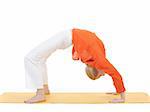 series or yoga photos. young woman in chakrasana pose on yellow pilates mat