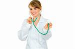 Smiling medical female doctor holding up stethoscope isolated on white