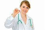 Smiling medical doctor woman holding  pill in hand isolated on white