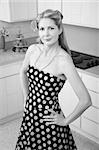 Confident Caucasian woman with hand on hips in kitchen