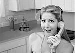 Happy retro-styled Caucasian woman on phone in kitchen