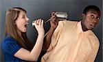 Woman shouts at a man through stringed cans on gray background