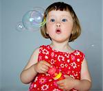 cute little girl playing with bubbles in the studio