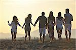 Group of happy young people in circle at beach have fun