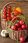 Two wicker baskets with fresh garden vegetables.
