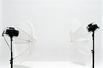 Two simple studio monoblocks with umbrellas used for object shooting. White paper background