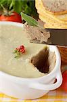 Pate on a knife with leaf of sade close-up.