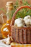 Garden garlic on basket, thyme and olive oil.