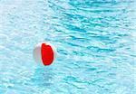 Beach ball floating in a swimming pool on a hot summer day