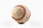 An old worn baseball against a white background