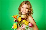 Happy close-up on a green background happy young woman hugging a bouquet of colorful tulips