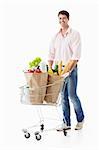 A young man with a cart with food on a white background