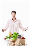 Surprised man with a cart with food on a white background