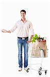 A happy man with a cart with food on a white background