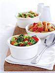 Bean Salads in white china bowls on a wooden board