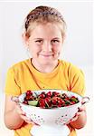Cute child holding a bowl of fresh cherries