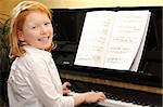Portrait of a happy young girl playing piano