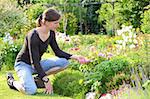 A young woman enjoys the flowers in the garden