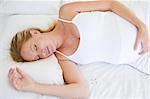 Pregnant woman lying in bed sleeping