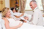 Doctor talking to pregnant woman holding chart and smiling